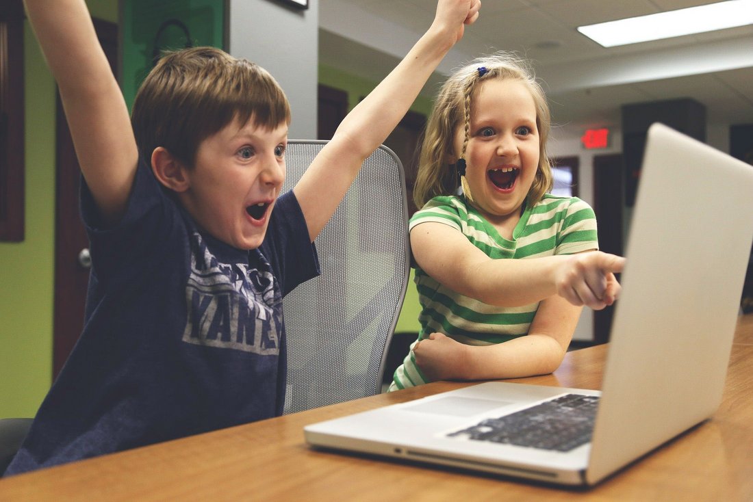 fröhliche Kinder vor einem Laptop